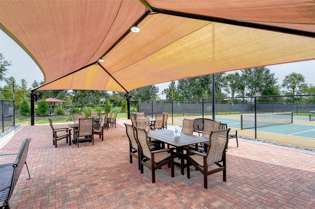 13604 Messina Loop, Unit 203 Bradenton, FL 34211 - Photo 44 of 56 a view of a patio with a table chairs and a backyard