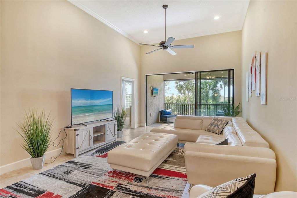 13604 Messina Loop, Unit 203 Bradenton, FL 34211 - Photo 5 of 56 a living room with furniture a flat screen tv and a large window