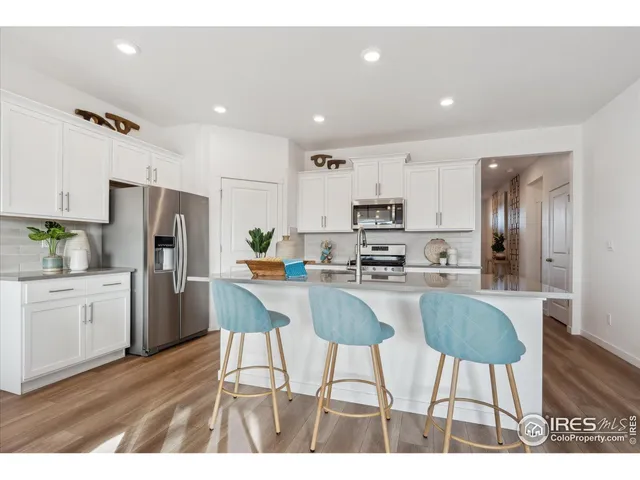 a kitchen with stainless steel appliances kitchen island granite countertop a refrigerator and a stove top oven