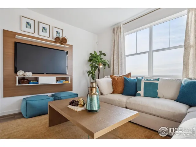 a living room with furniture a flat screen tv and a large window