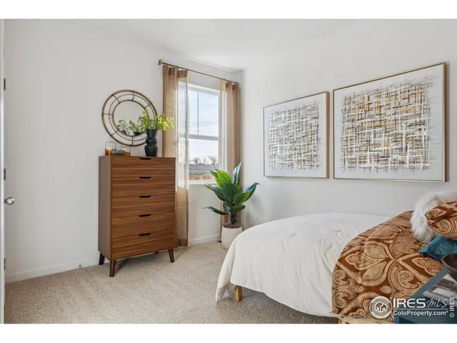 a bed sitting in a bedroom next to a window and dresser