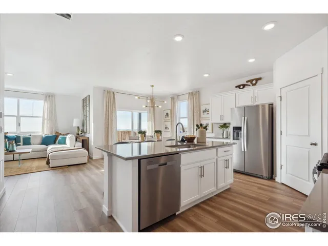 a kitchen with stainless steel appliances granite countertop a lot of counter space and wooden floor