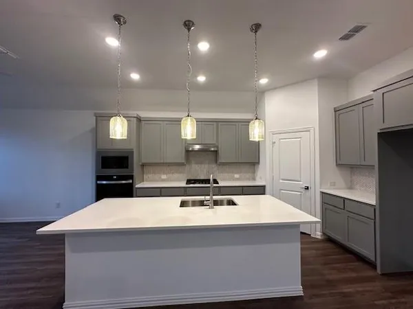 a kitchen with a sink and a chandelier