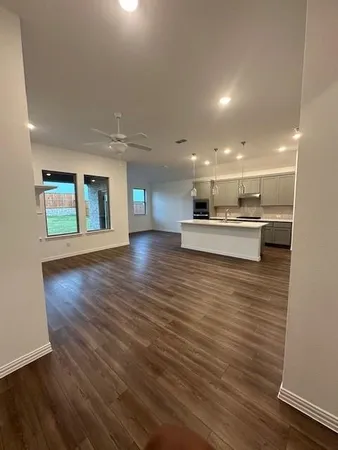 a kitchen with kitchen island wooden floor center island and stainless steel appliances