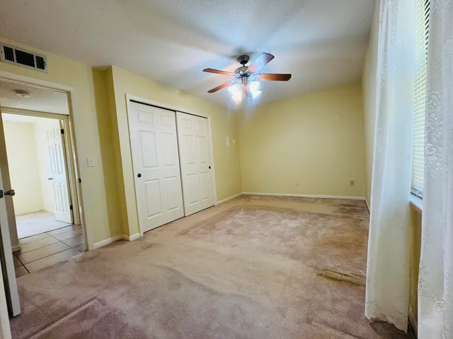 an empty room with a chandelier fan