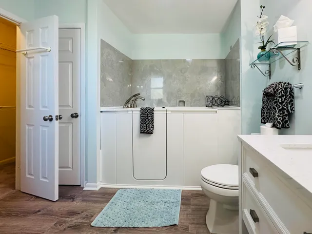 a bathroom with a granite countertop sink mirror vanity and toilet