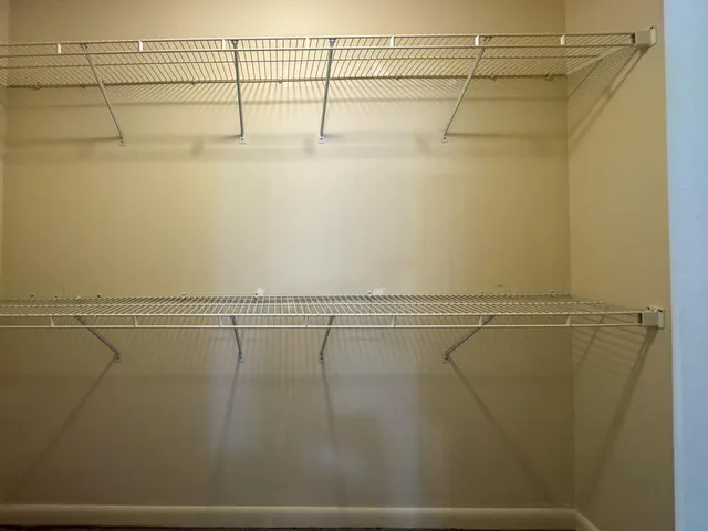 an empty room with a window and ceiling fan