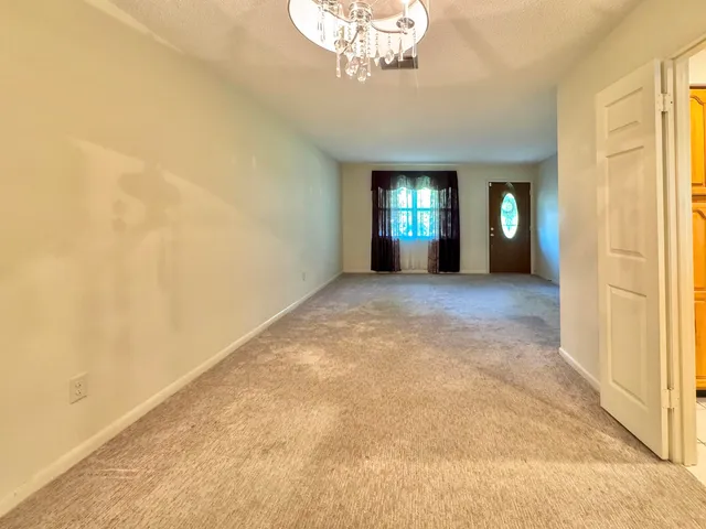 a view of a room with a chandelier fan and windows