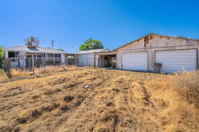 a backyard of a house with table and chairs