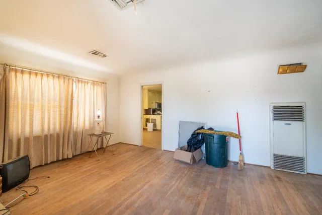a large kitchen with a wooden floor and a refrigerator