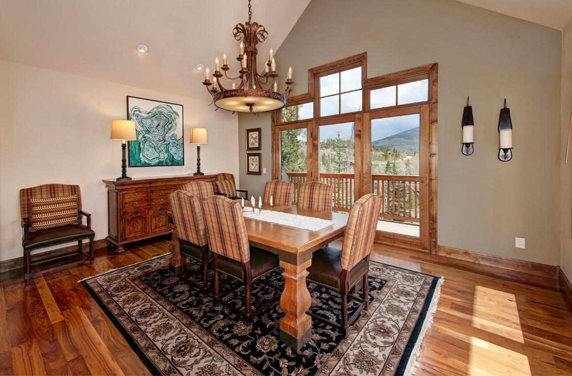 724 Willowbrook Road Silverthorne, CO 80498 - Photo 11 of 30 a dining room with wooden floor a chandelier a wooden table and chairs