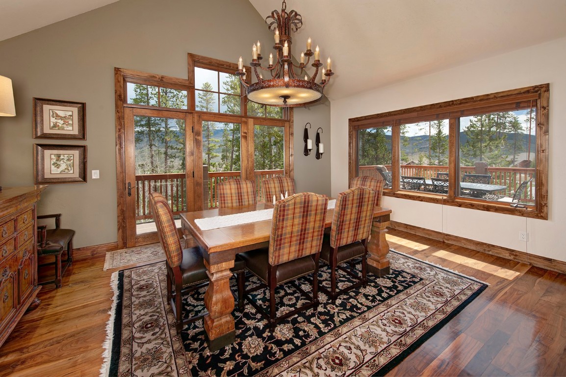 724 Willowbrook Road Silverthorne, CO 80498 - Photo 12 of 30 a dining room with wooden floor a chandelier a wooden table and chairs