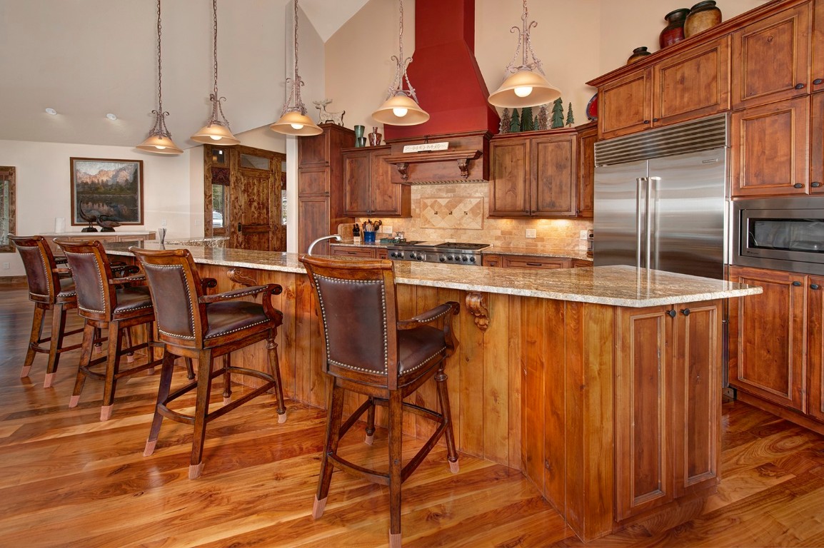 724 Willowbrook Road Silverthorne, CO 80498 - Photo 13 of 30 a kitchen with stainless steel appliances kitchen island granite countertop a table chairs sink and cabinets