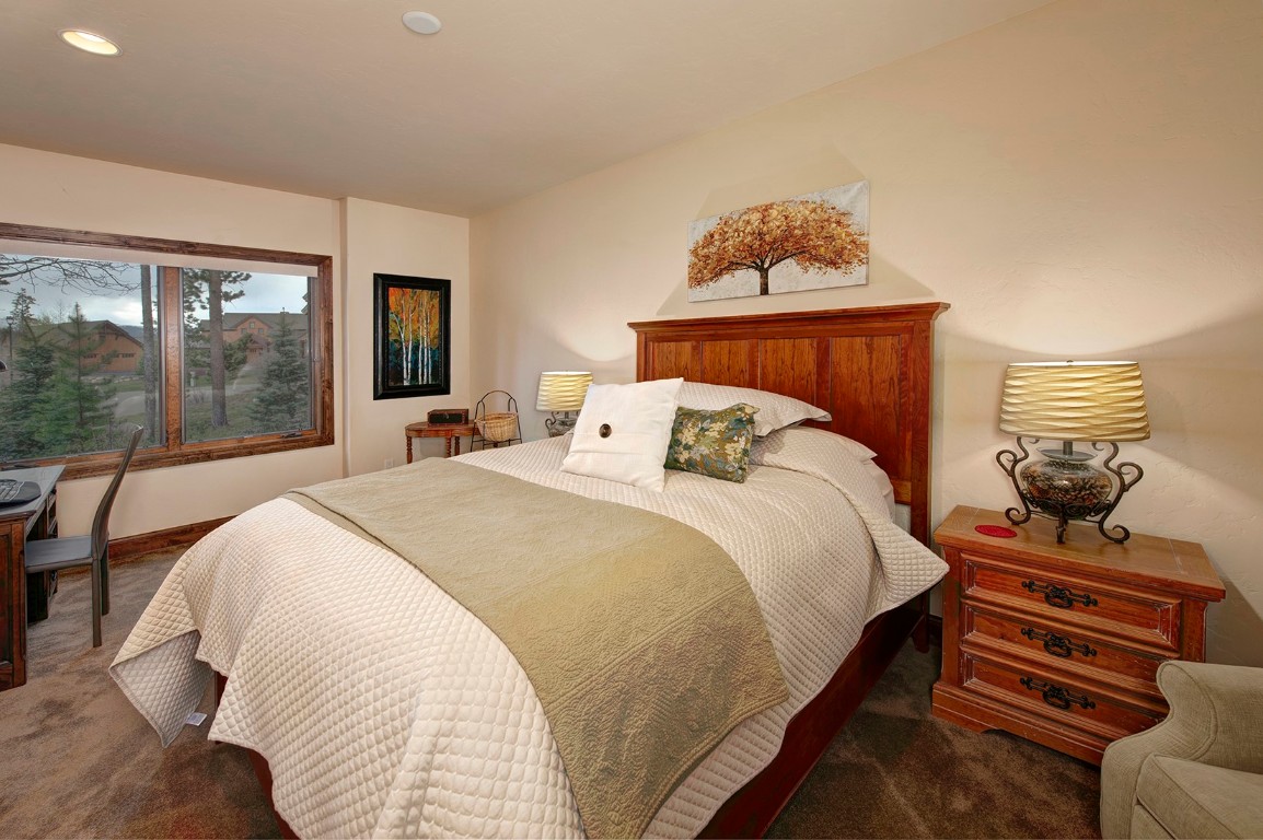 724 Willowbrook Road Silverthorne, CO 80498 - Photo 24 of 30 a bedroom with a bed and wooden floor