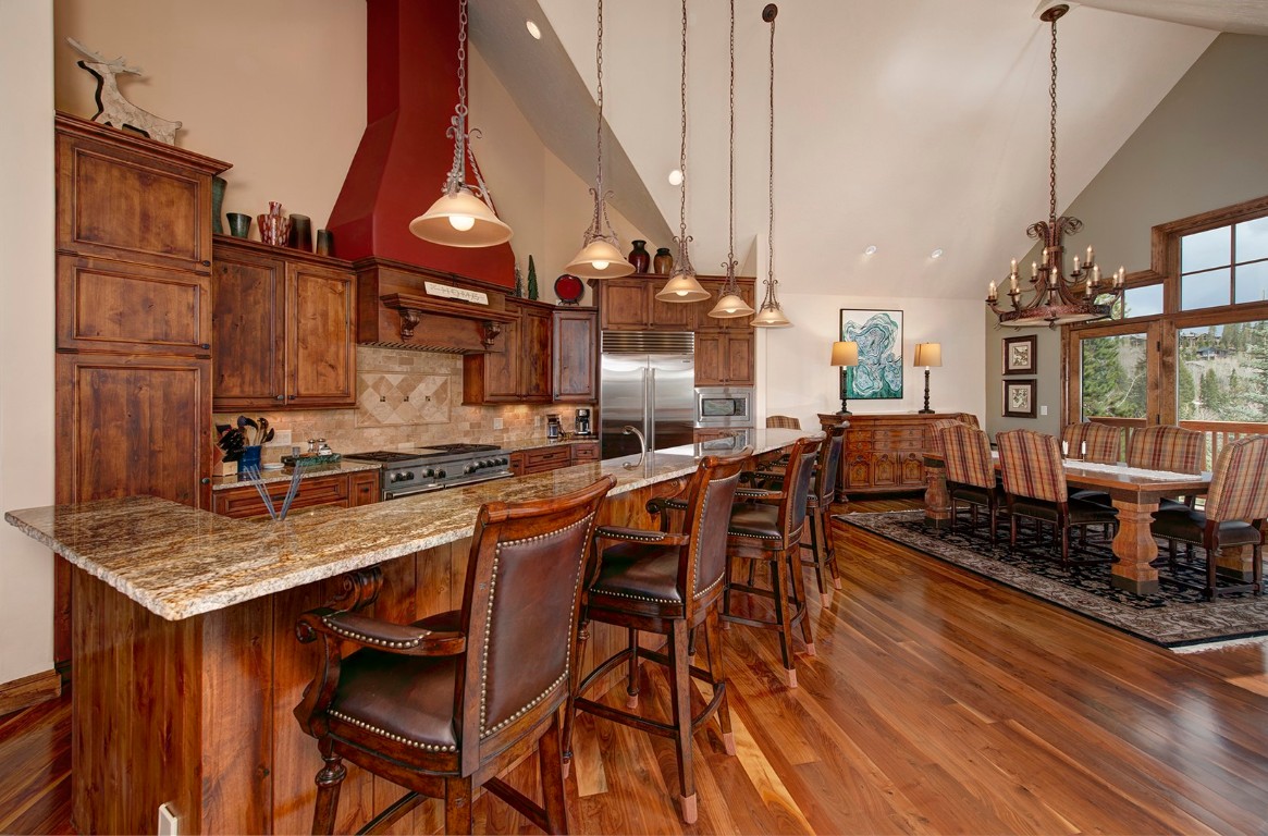 724 Willowbrook Road Silverthorne, CO 80498 - Photo 10 of 30 a kitchen with stainless steel appliances granite countertop a stove top oven a sink a dining table and chairs with wooden floor