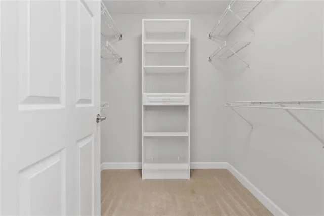 a view of walk in closet with empty racks