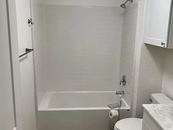 a white bath tub sitting next to a white toilet