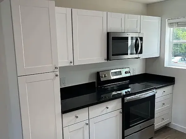 a kitchen with stainless steel appliances white cabinets and a stove a microwave
