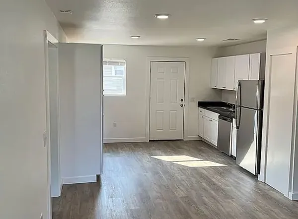 a kitchen with granite countertop a refrigerator and a sink