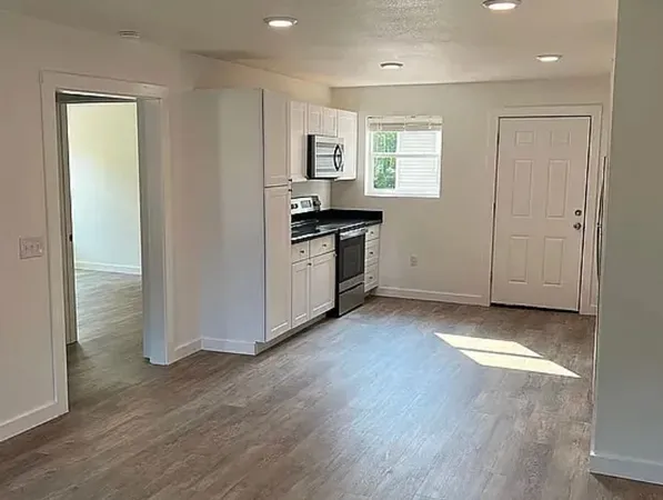 a view of a kitchen with a sink a refrigerator and window