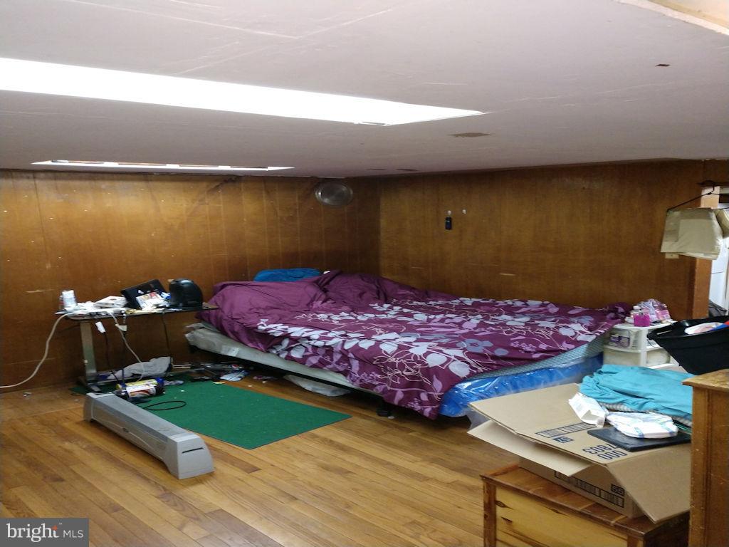 8361 Ridgely Oak Road Baltimore, MD 21234 - Photo 13 of 17 a bedroom with a bed and wooden floor