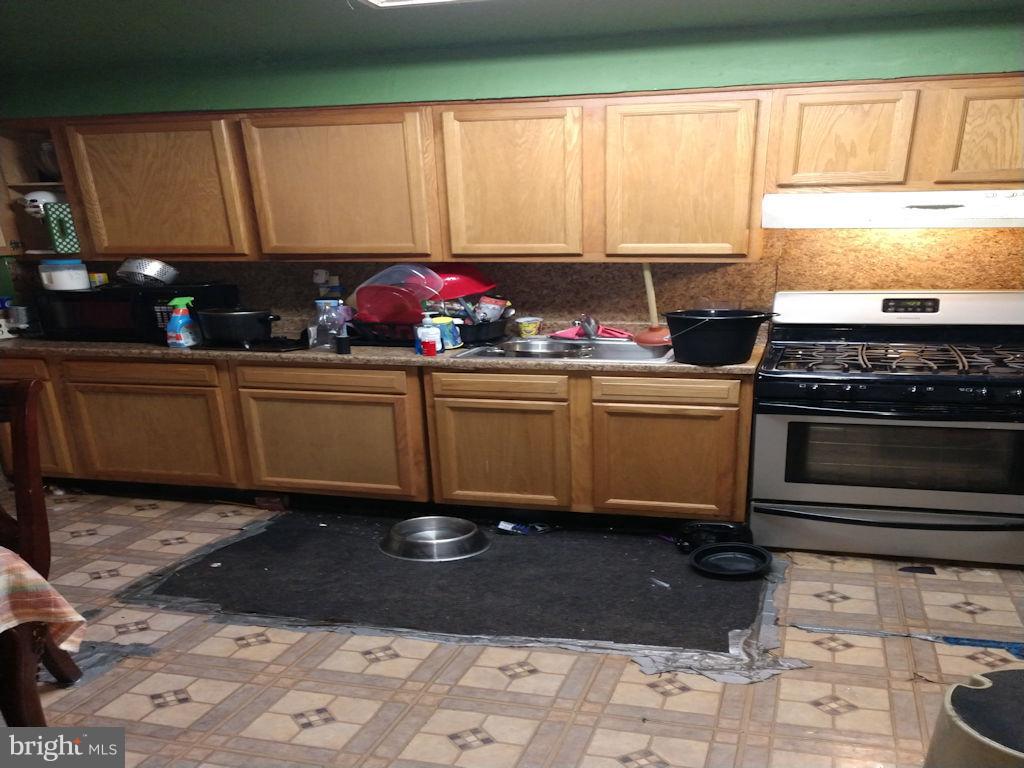 8361 Ridgely Oak Road Baltimore, MD 21234 - Photo 5 of 17 a kitchen with granite countertop a stove a sink and a cabinets