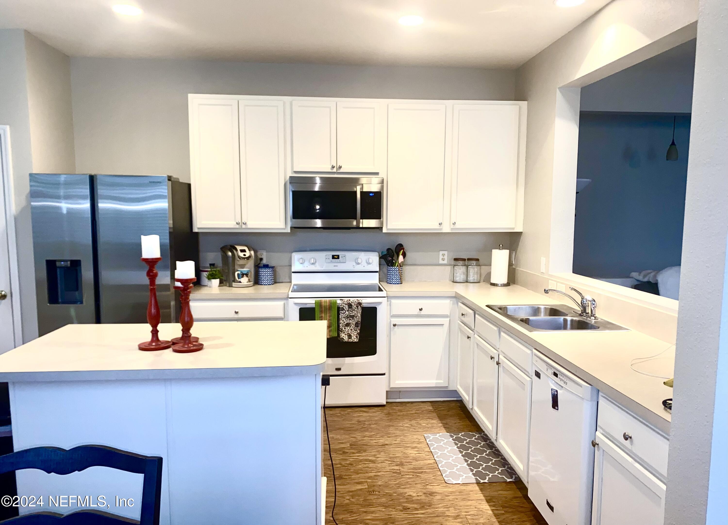 1108 Nochaway Drive St. Augustine, FL 32092 - Photo 7 of 11 a kitchen with stainless steel appliances kitchen island granite countertop a sink stove refrigerator and cabinets