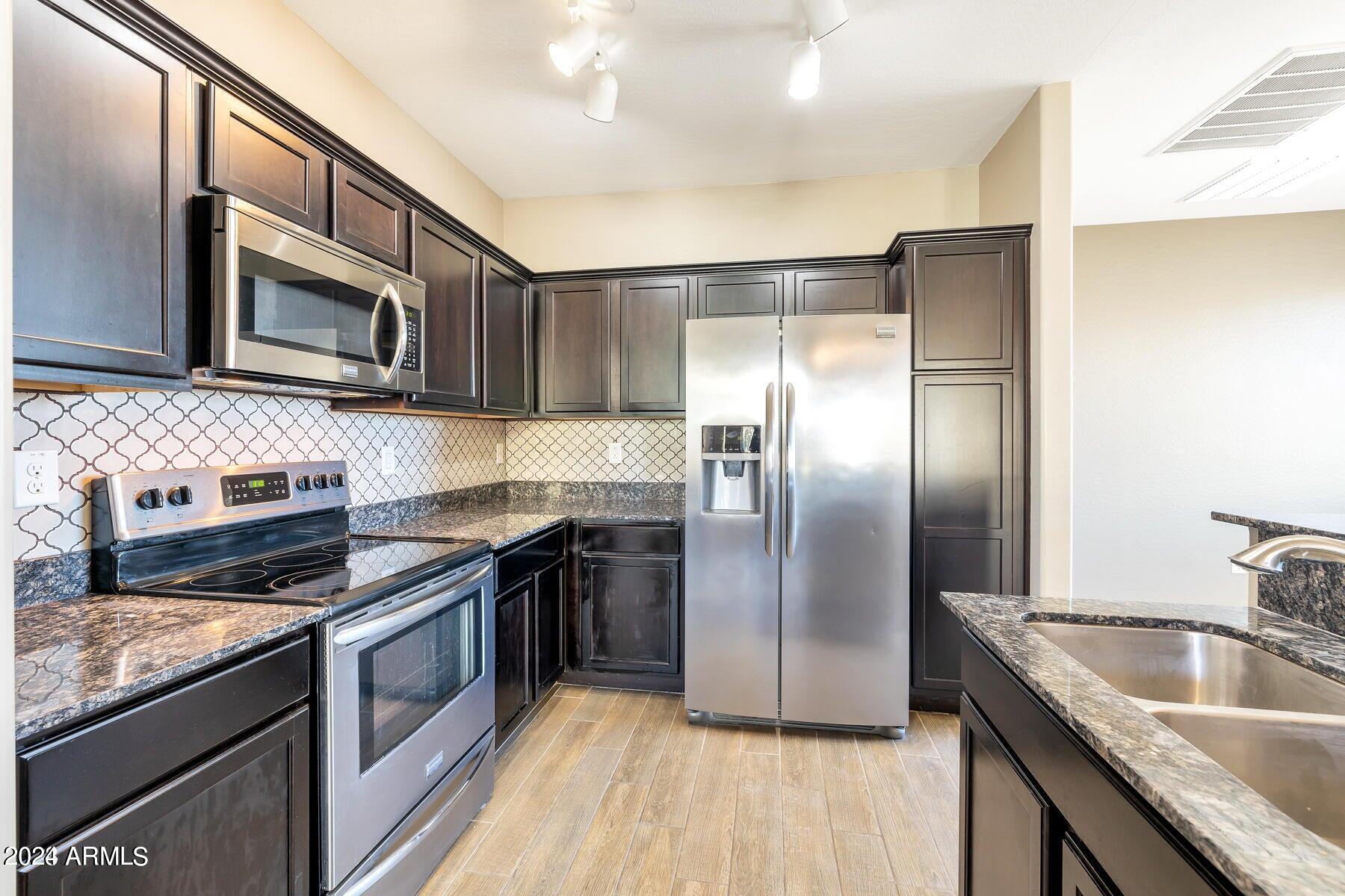 2150 West Alameda Road, Unit 1169 Phoenix, AZ 85085 - Photo 26 of 26 a kitchen with stainless steel appliances granite countertop a sink a stove a refrigerator and cabinets
