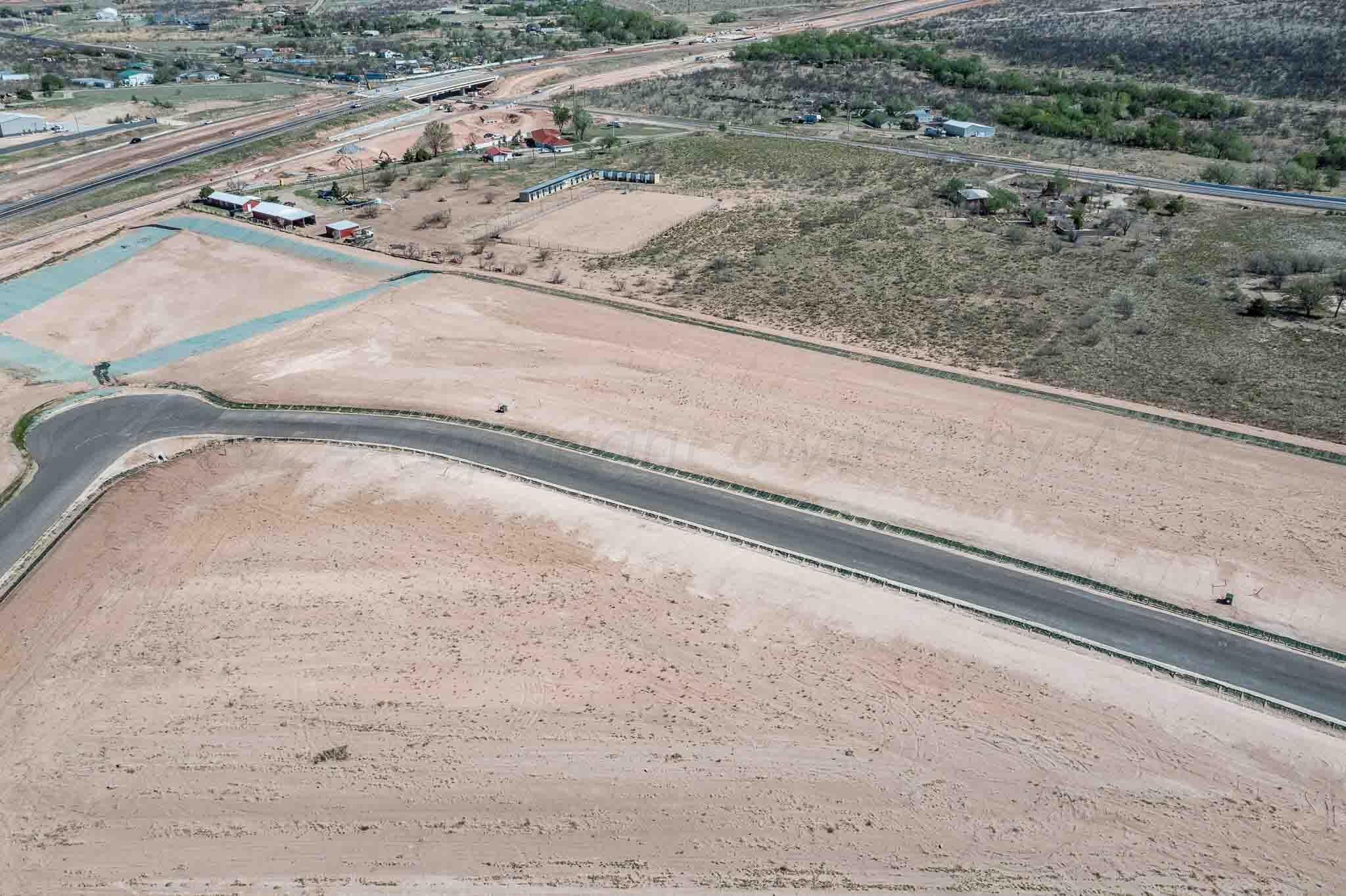 a view of a dry yard with wooden fence