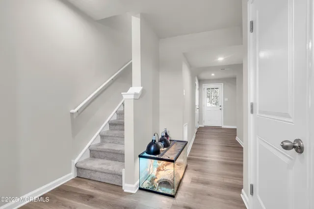 a view of a hallway with wooden floor and staircase