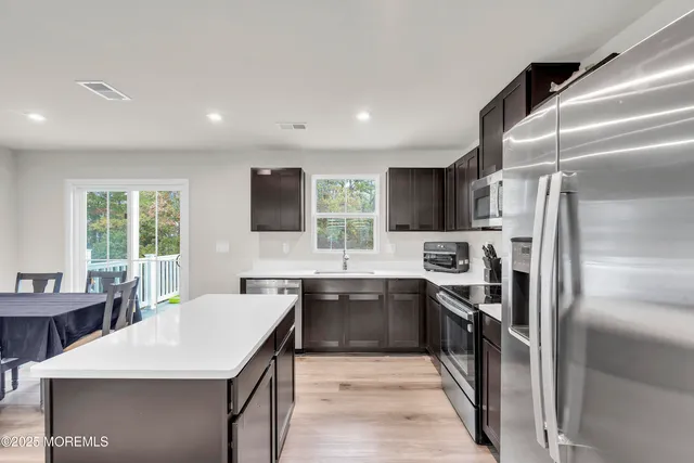 a kitchen with stainless steel appliances a sink stove refrigerator and cabinets