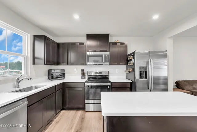a kitchen with stainless steel appliances a refrigerator stove and sink