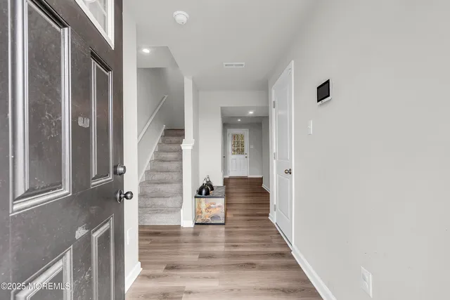 a view of a hallway with wooden floor and staircase