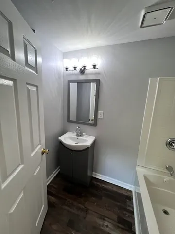 a bathroom with a sink and mirror with shower