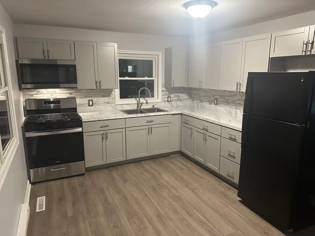 a kitchen with a sink stainless steel appliances and cabinets