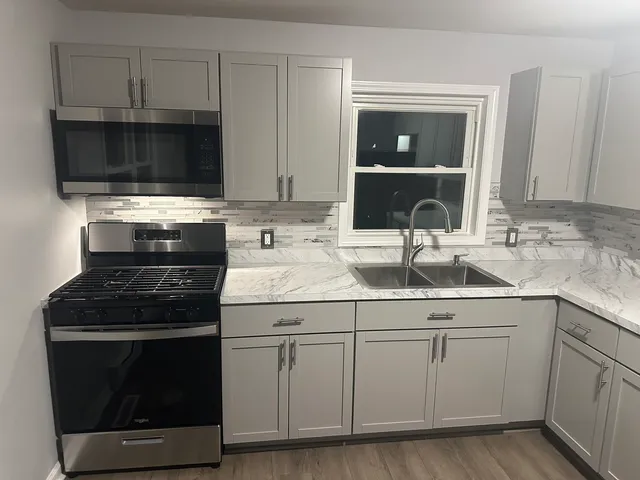 a kitchen with white cabinets and appliances
