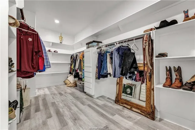 a view of walk in closet with clothes and shoes
