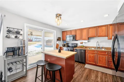 a kitchen with stainless steel appliances granite countertop a stove top oven a sink dishwasher and cabinets with wooden floor