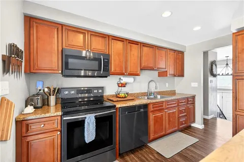 a kitchen with stainless steel appliances granite countertop a stove a sink and a microwave