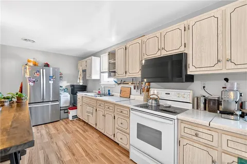 a kitchen with stainless steel appliances granite countertop a stove refrigerator and a microwave