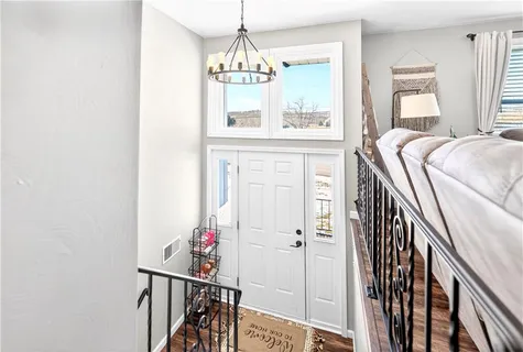 a view of a hallway with windows and chandelier