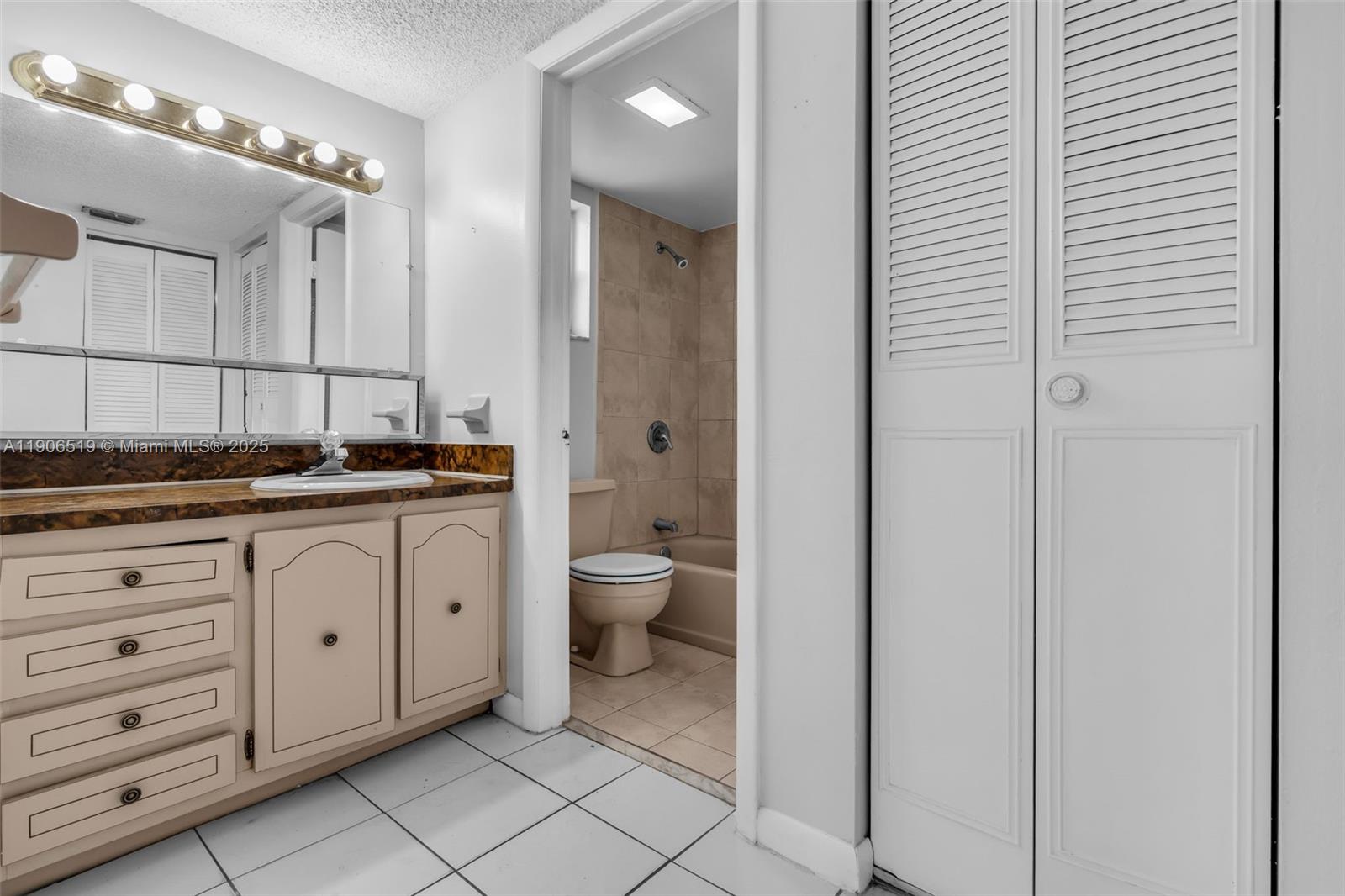 7345 West 4th Avenue, Unit 402 Hialeah, FL 33014 - Photo 17 of 22 a spacious bathroom with a granite countertop sink a toilet and a mirror