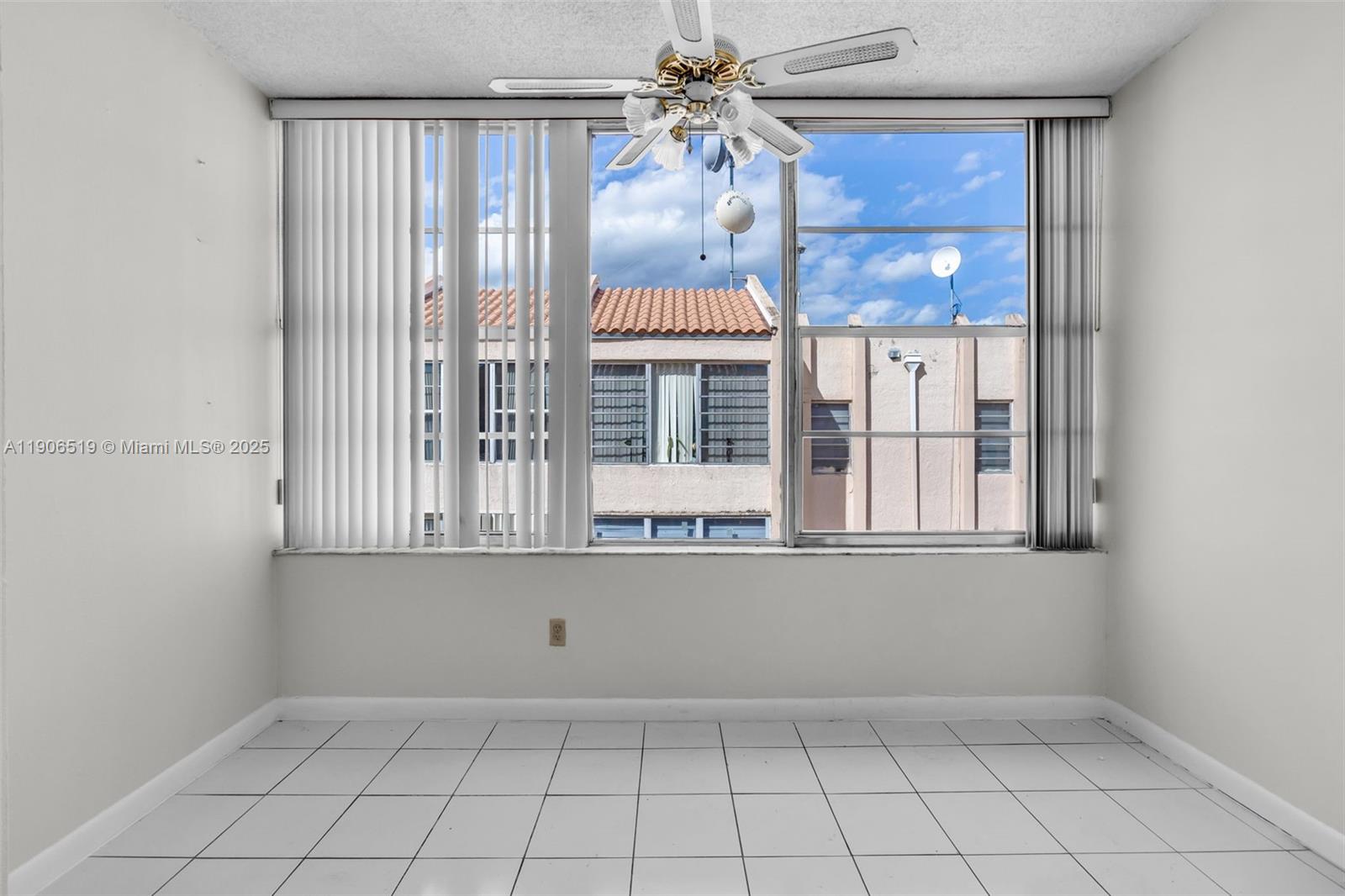 7345 West 4th Avenue, Unit 402 Hialeah, FL 33014 - Photo 5 of 22 an empty room with windows and fan