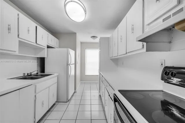 a kitchen with a sink appliances and cabinets