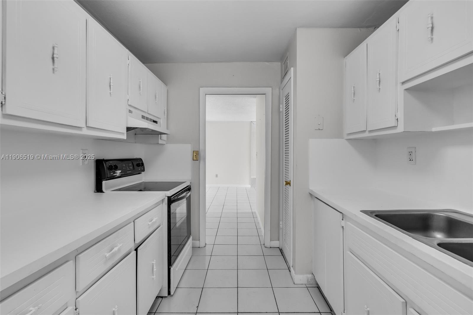 7345 West 4th Avenue, Unit 402 Hialeah, FL 33014 - Photo 9 of 22 a kitchen with a sink and white cabinets