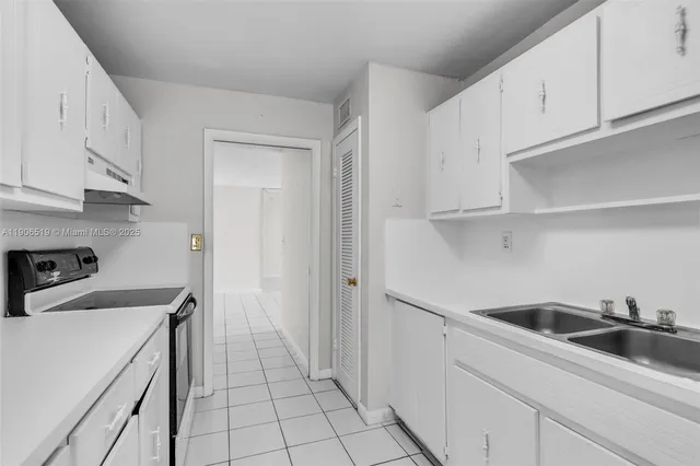 a view of a kitchen with white cabinets