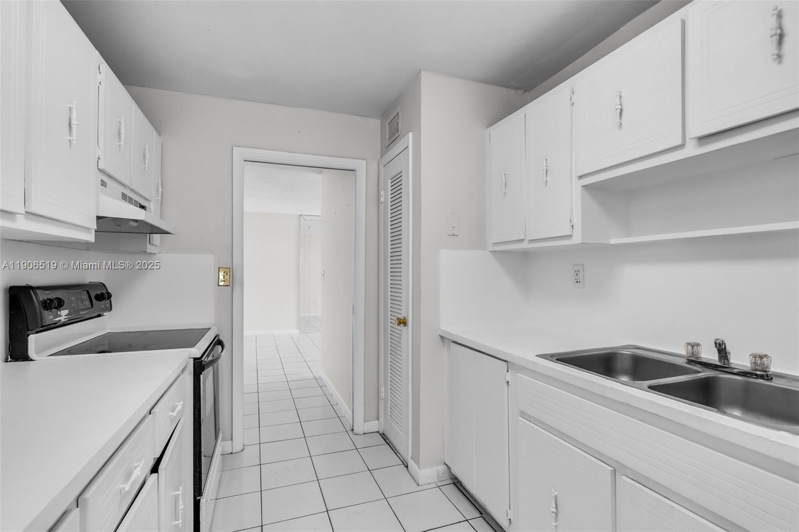 7345 West 4th Avenue, Unit 402 Hialeah, FL 33014 - Photo 10 of 22 a view of a kitchen with white cabinets