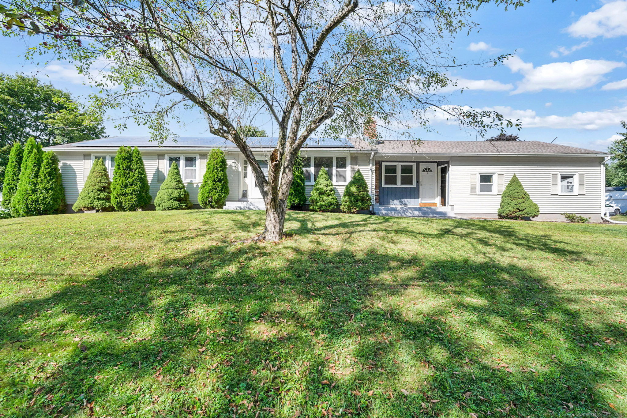 a view of a house with a big yard and large trees