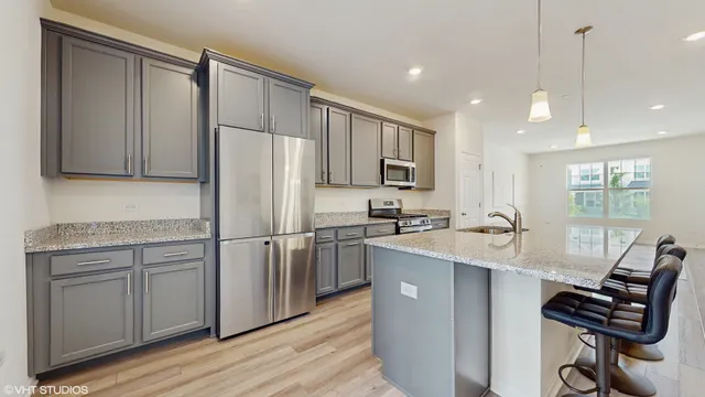a kitchen with kitchen island white cabinets and stainless steel appliances