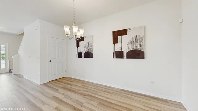 a view of a room with wooden floor and chandelier